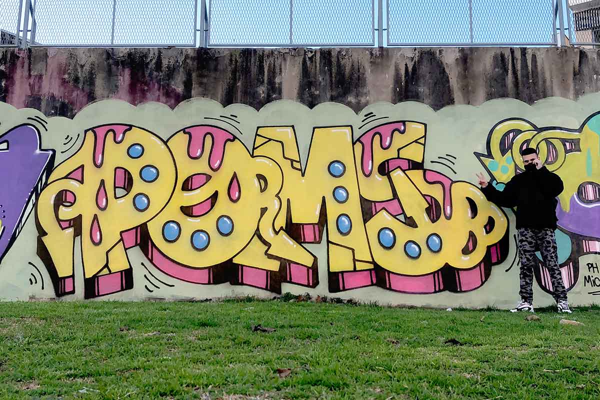 Poms posa junto a uno de sus grafitis en Avellaneda
