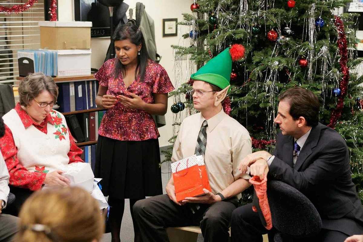 mindy kaling, steve carell y rainn wilson reciben regalos navideños en una escena de the office