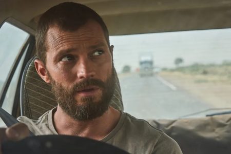 Jamie Dornan maneja un auto en una escena de El turista