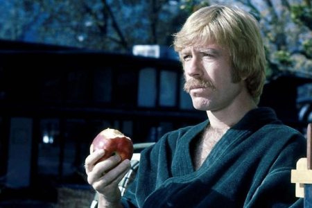 Las dos películas en las que Chuck Norris hace de villano Chuck Norris con una manzana en la mano