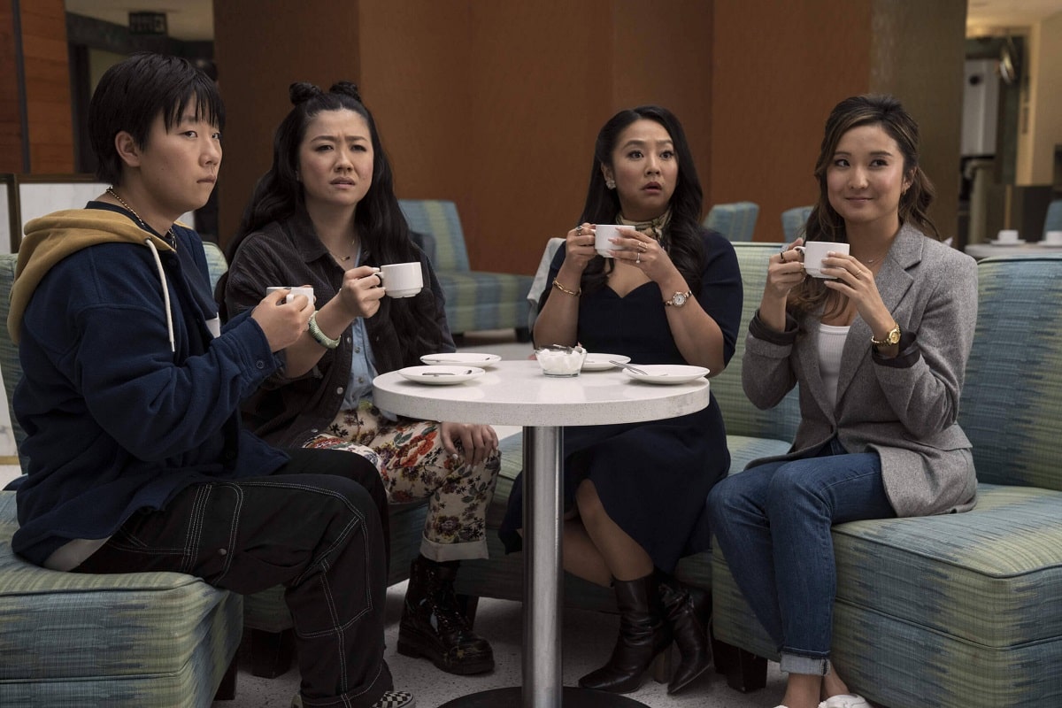Ashley Park, Sherry Cola, Stephanie Hsu y Sabrina Wu sentadas a una mesa con tazas en la mano