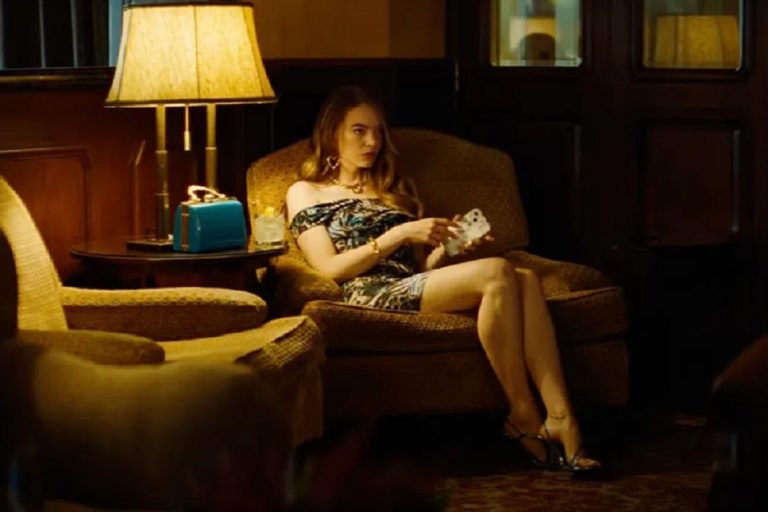 Emma Stone sentada en un sillón en una escena de Kinds of Kindness