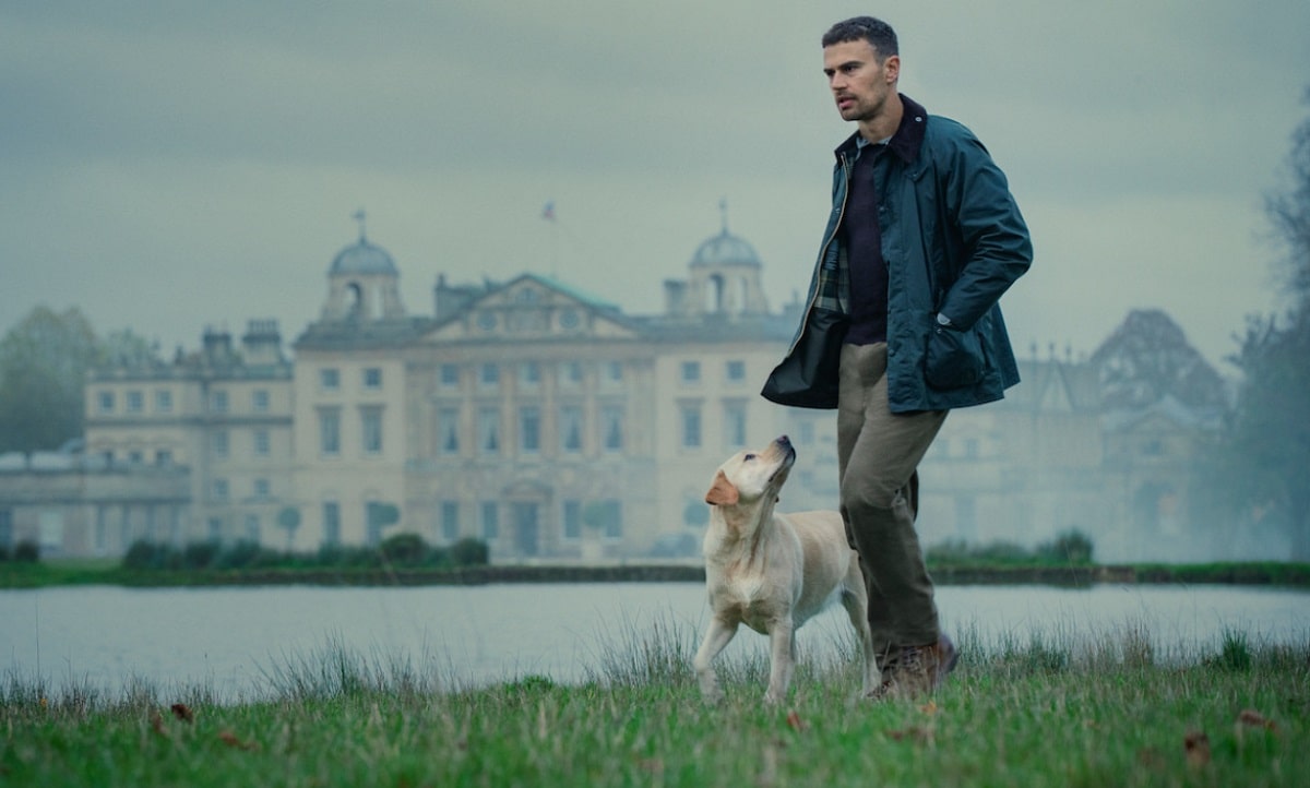 Theo James camina con un perro en la serie Los caballeros