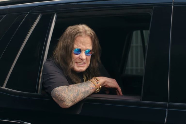 Ozzy Osbourne apoyado sobre la ventana de un auto