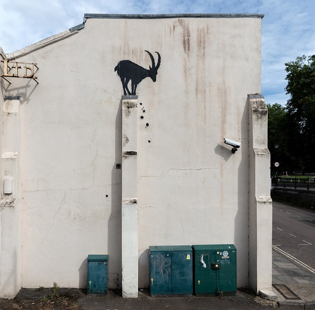 Mural de una cabra negra parada sobre una columna