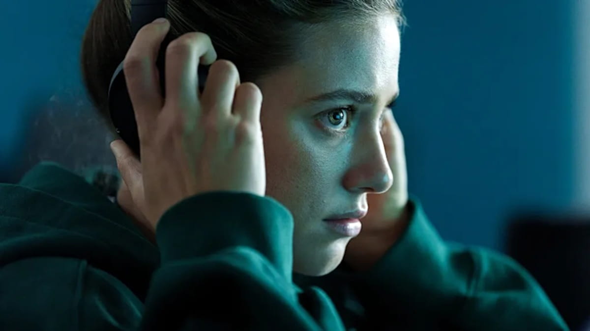 Lili Reinhart en la película Red tóxica acomodándose auriculares