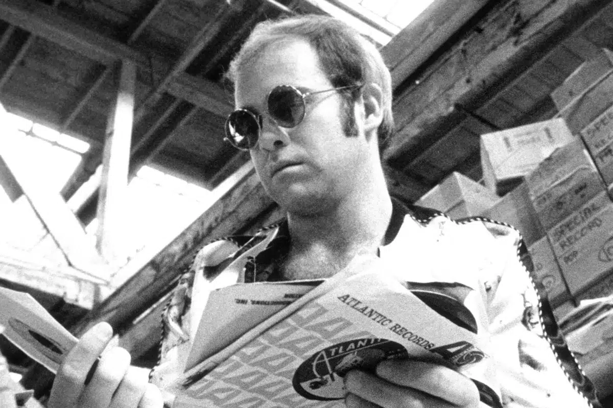 Elton John con discos en la mano