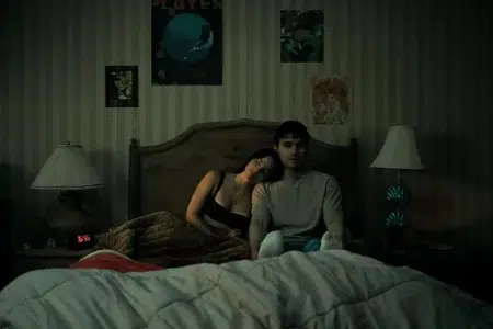 Por qué Obsesión es el nuevo suceso de terror que está rompiendo récords Michael Johnston e Inde Navarrette sentados en una cama en el film Obsesión