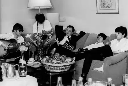 The Beatles sentados en sillones